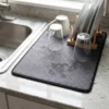 Absorbent kitchen counter mat used as a dish drying mat beside the sink